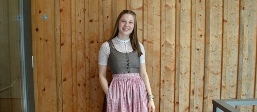 junges Mädchen, lange blonde Haare, braun-rotes Dirndl