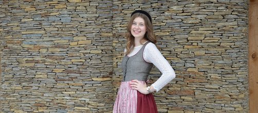 braunes Dirndl mit roter Schürze, lange blonde Haare