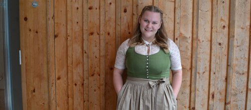 junges Mädchen, lange blonde Haare, grünes Dirndl