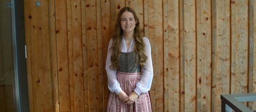 junges Mädchen, lange blonde Haare, braun-rotes Dirndl