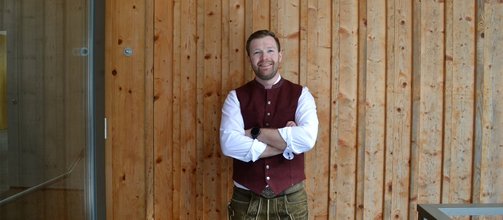 junger Mann mit Bart, weißes Hemd, rotes Gilet